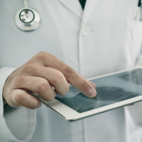 Ein Arzt nutzt ein Tablet (Symbolbild).