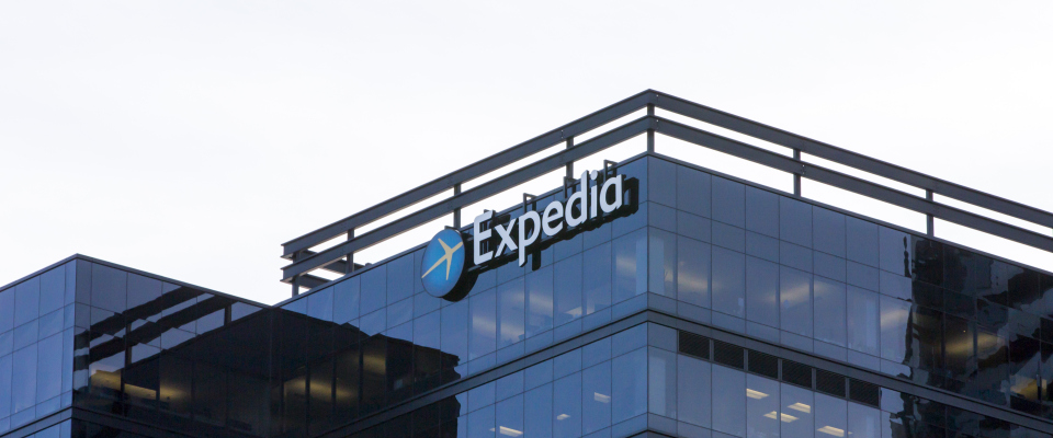 Das Logo des reiseanbieters Expedia an einem Bürogebäude.