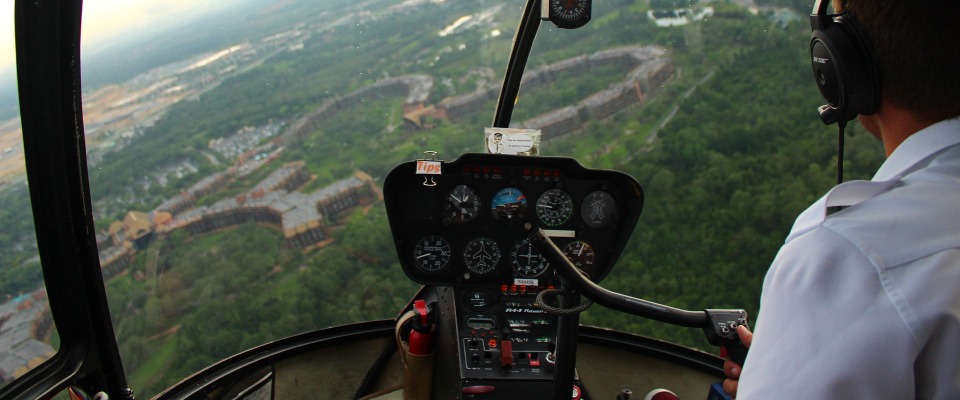 Der Pilot eines Hubschraubers blickt aus der Vogelperspektive auf eine Landschaft (Symbolbild).