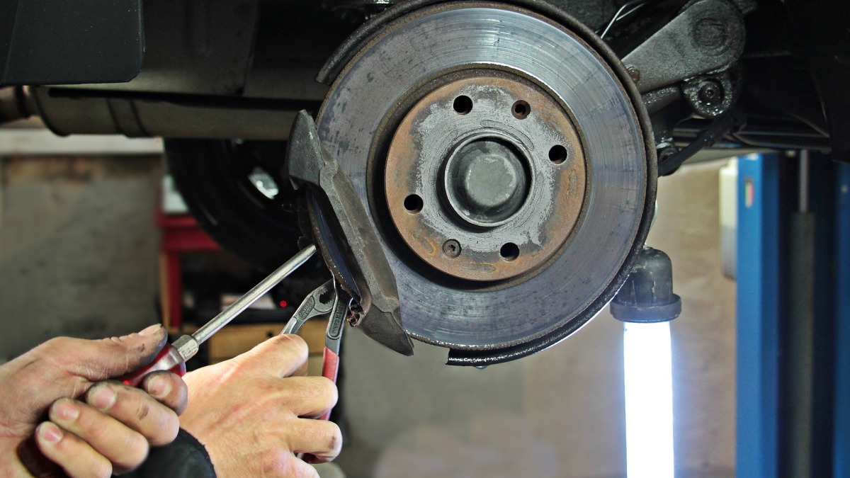 Die Bremsen eines Autos werden in einer Werkstatt überprüft (Symbolbild).