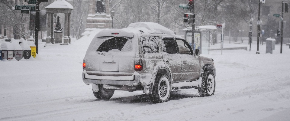 Ein Auto auf einer verschneiten Straße (Symbolbild).