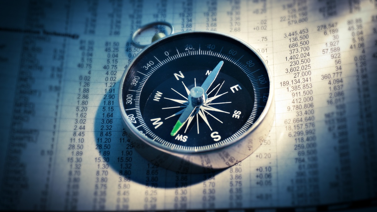 Ein Kompass auf einer Zeitung mit Börsenkursen (Symbolbild).