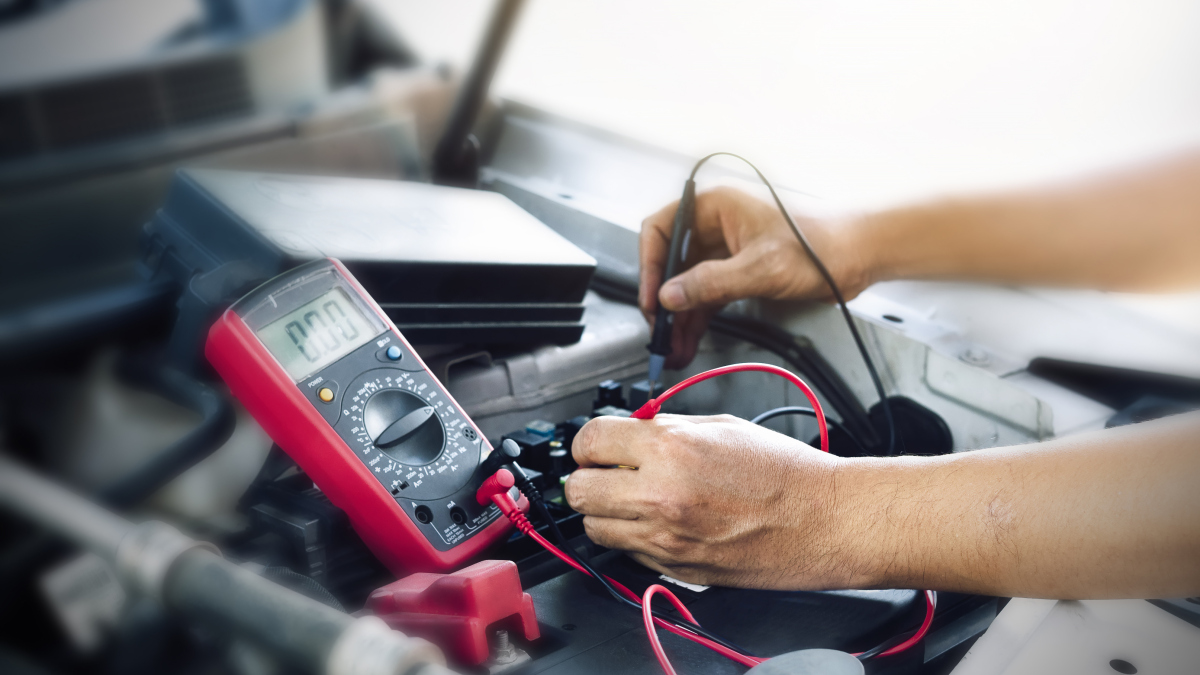 Ein Mechaniker testet eine Autobatterie (Symbolbild).