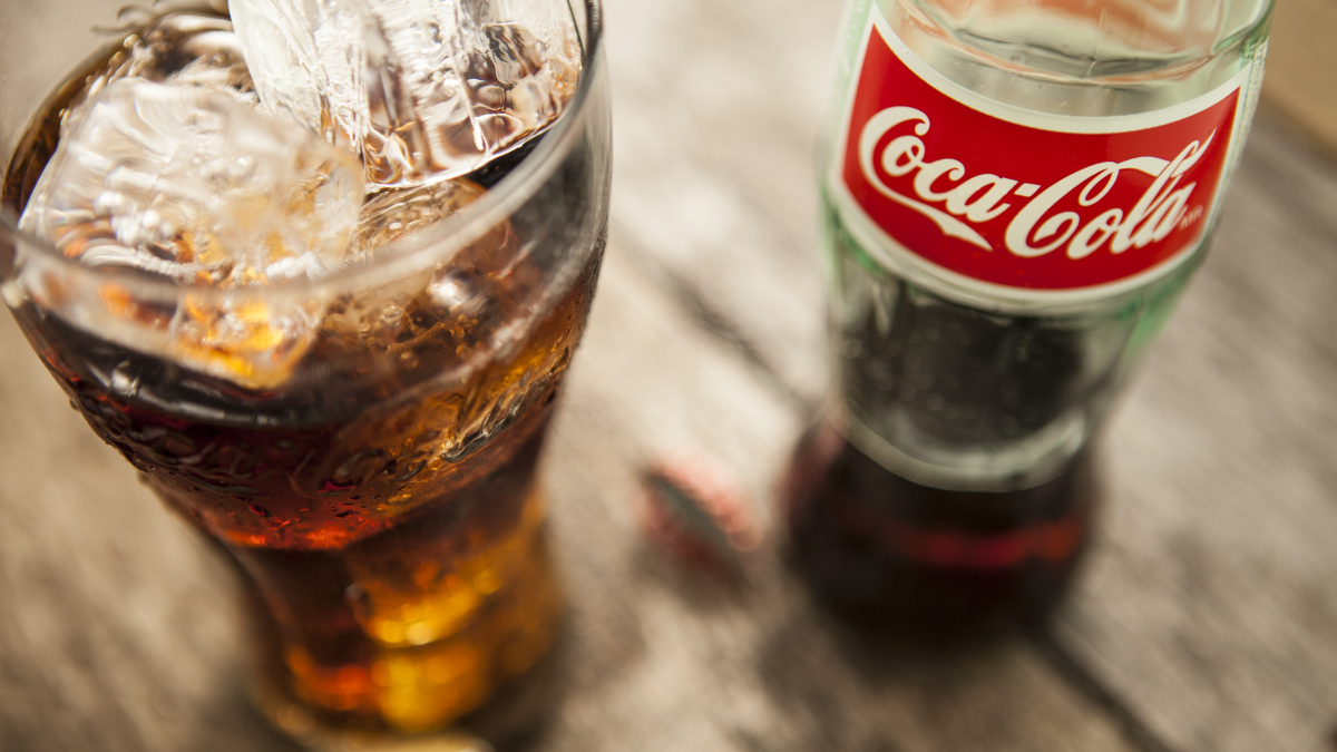 Eine Coca-Cola Flasche und ein Coca-Cola Glas.