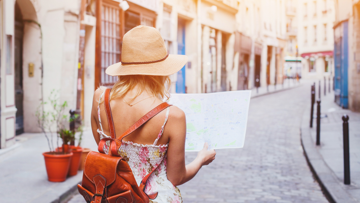 Eine Frau orientiert sich auf einer Reise auf einem Stadtplan. (Symbolbild)