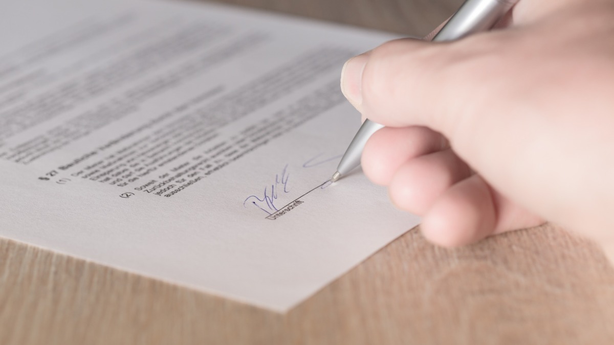 Eine Frau unterschreibt einen Vertrag (Symbolbild).