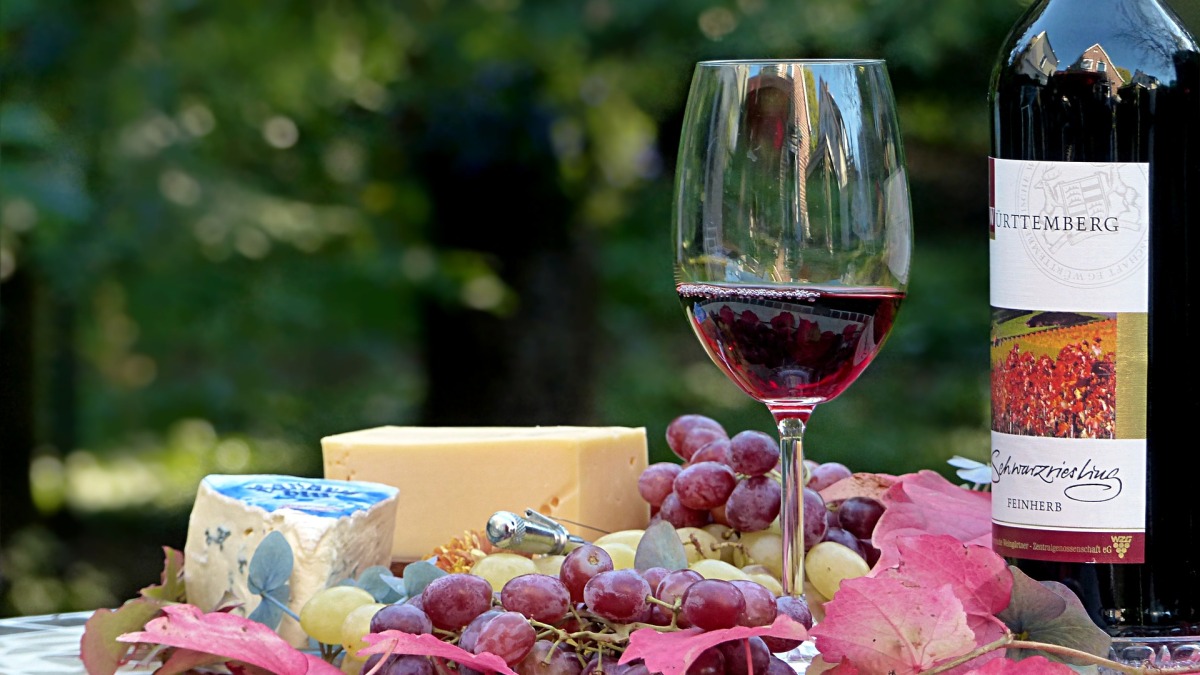 Eine Käseplatte mit Trauben und Wein (Symbolbild).