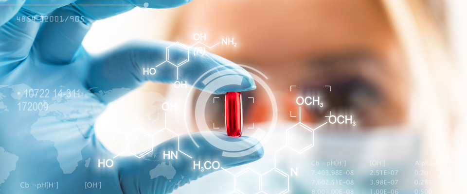 Eine Wissenschaftlerin prüft eine rote Pille (Symbolbild).
