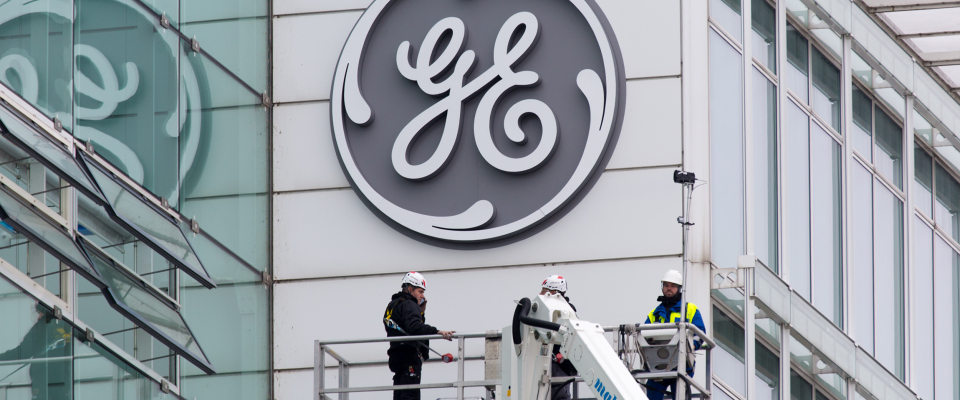 Das Logo von General Electric wird an einem Gebäude angebracht.