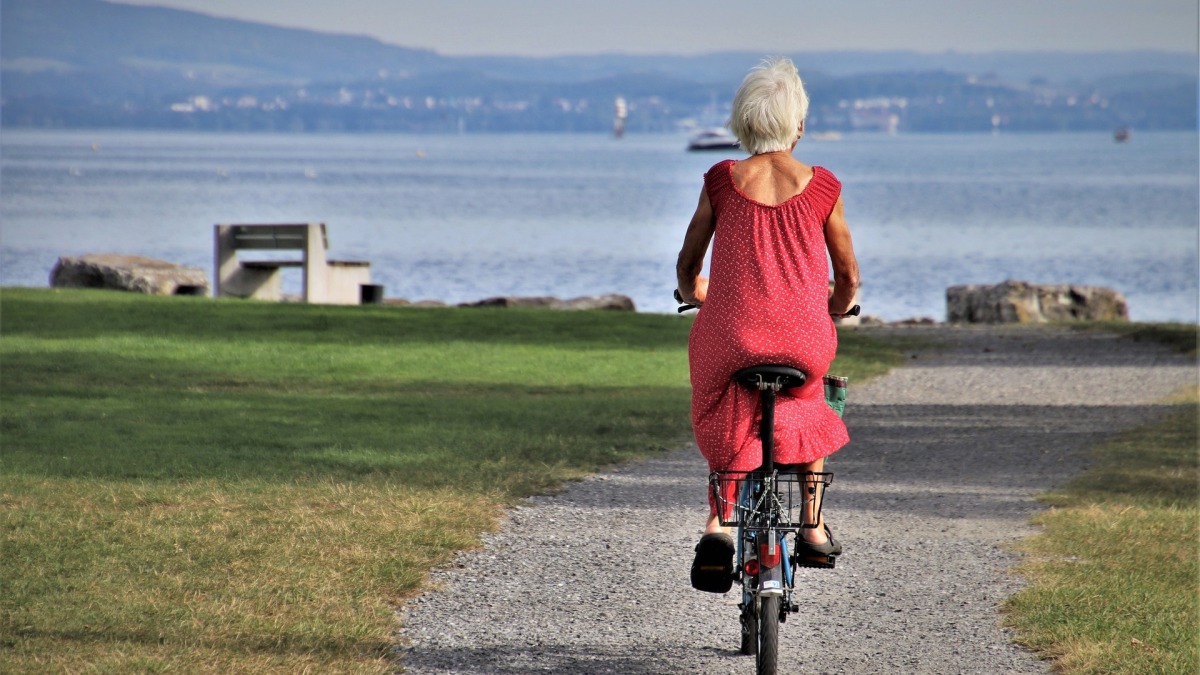Seniorin, die am Bodensee Fahrrad fährt. (Symbolbild)